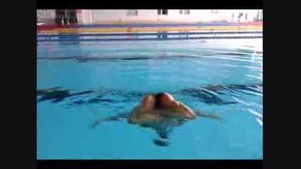 انجام یکی از تمرینهای شنای موزون توسط یک مرد