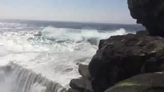 لحظه سقوط دختر جوان از بالای صخره توسط موج عظیم