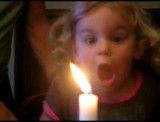 زور زدن خنده دار دختر کوچولو برای خاموش کردن شمع