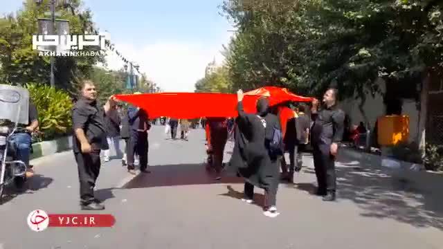 متبرک شدن زائران به پرچم حرم امام حسین (ع) در پیاده روی جاماندگان اربعین