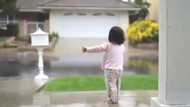 ‫شادی و هیجان دختر بچه نوپا از اولین تجربه زیر باران بودن‬‎